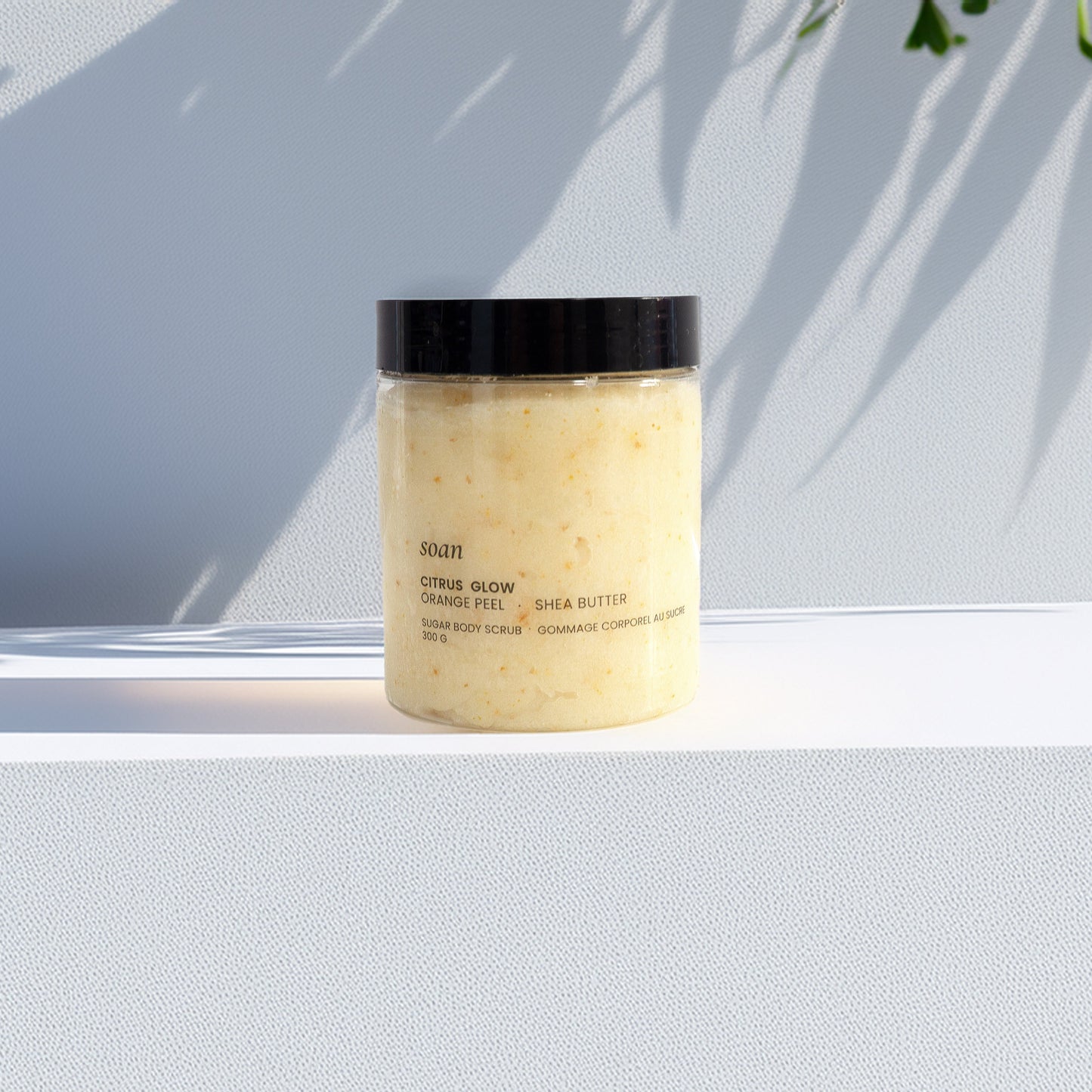 Natural sugar body scrub with uplifting citrus scent, perfect for exfoliating and moisturizing dry skin during self-care routines.