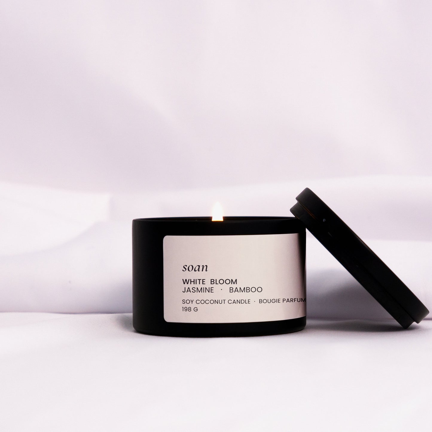 Minimalist White Bloom candle in a metal tin, styled with floral elements to evoke a serene garden atmosphere