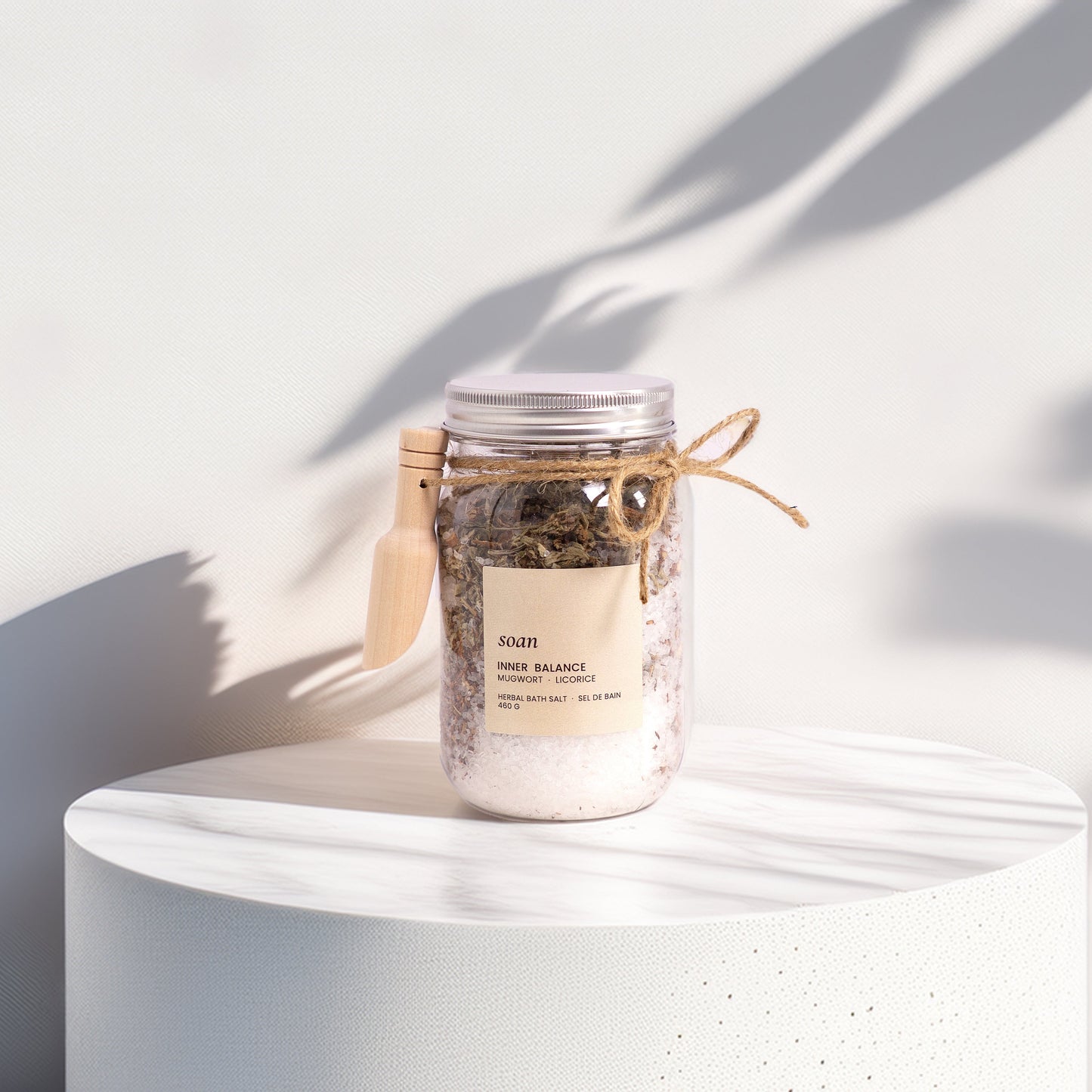 Jar of bath salts on a white surface with a white background