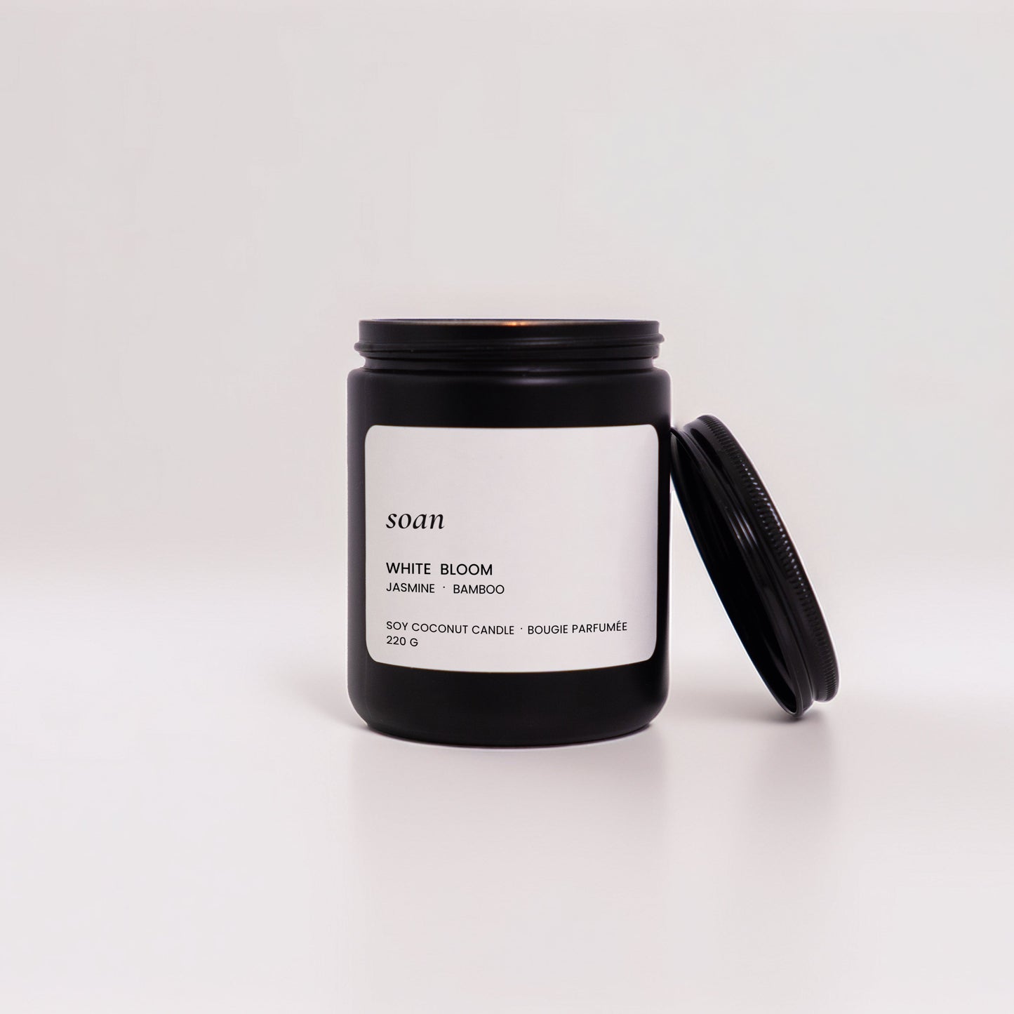Black candle jar with white label on a white background