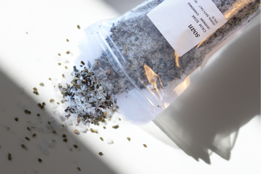 bath salt container with spilled contents on a white surface