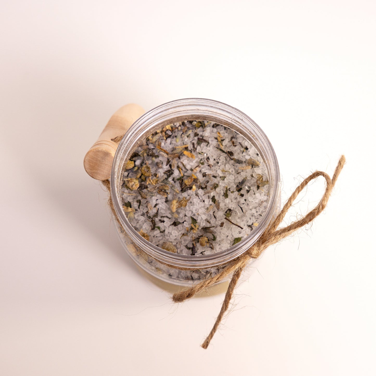 Jar of decorative sand with a wooden lid on a light background
