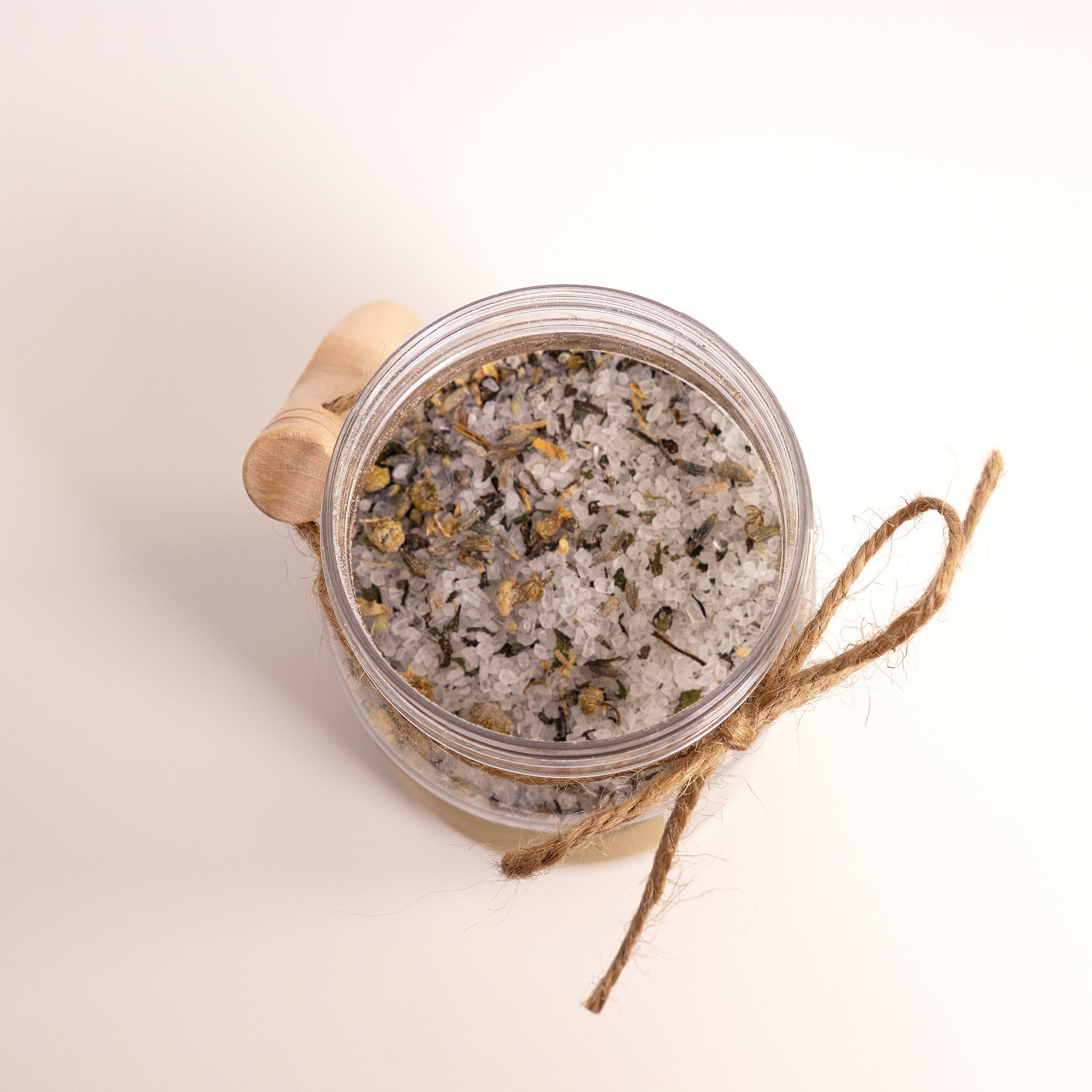 Jar of decorative sand with a wooden lid on a light background