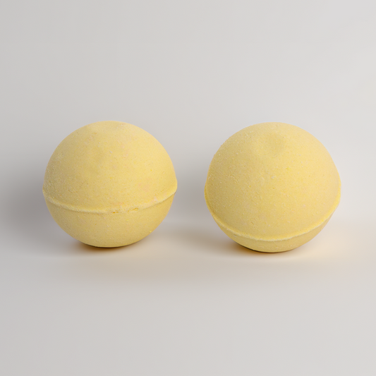 Two yellow bath bombs on a light gray background