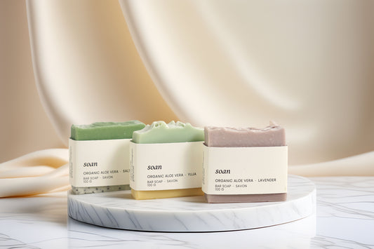 Three Aloe Vera soaps on a marble stand with a neutral background