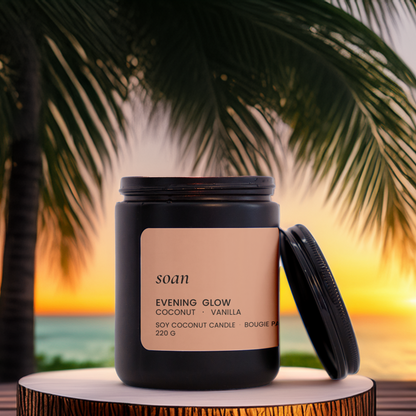 Candle on a wooden stand with palm trees and sunset in the background