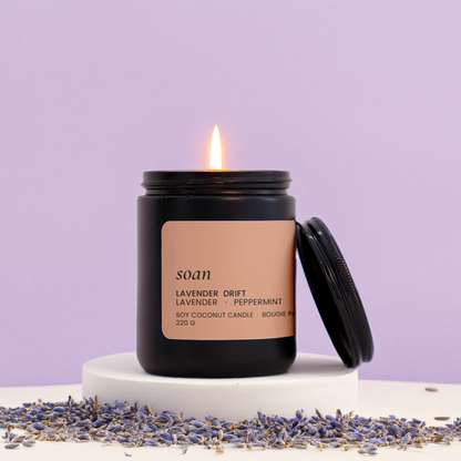 Candle with 'soan' branding on a purple background