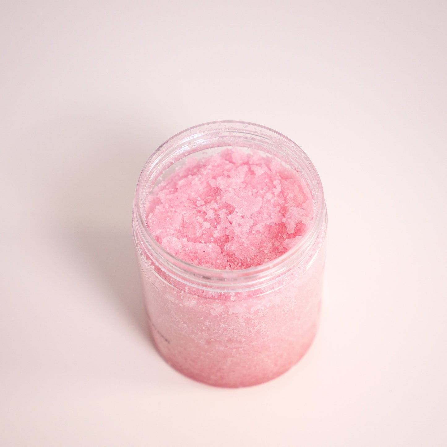 Jar of pink bath salt on a white background