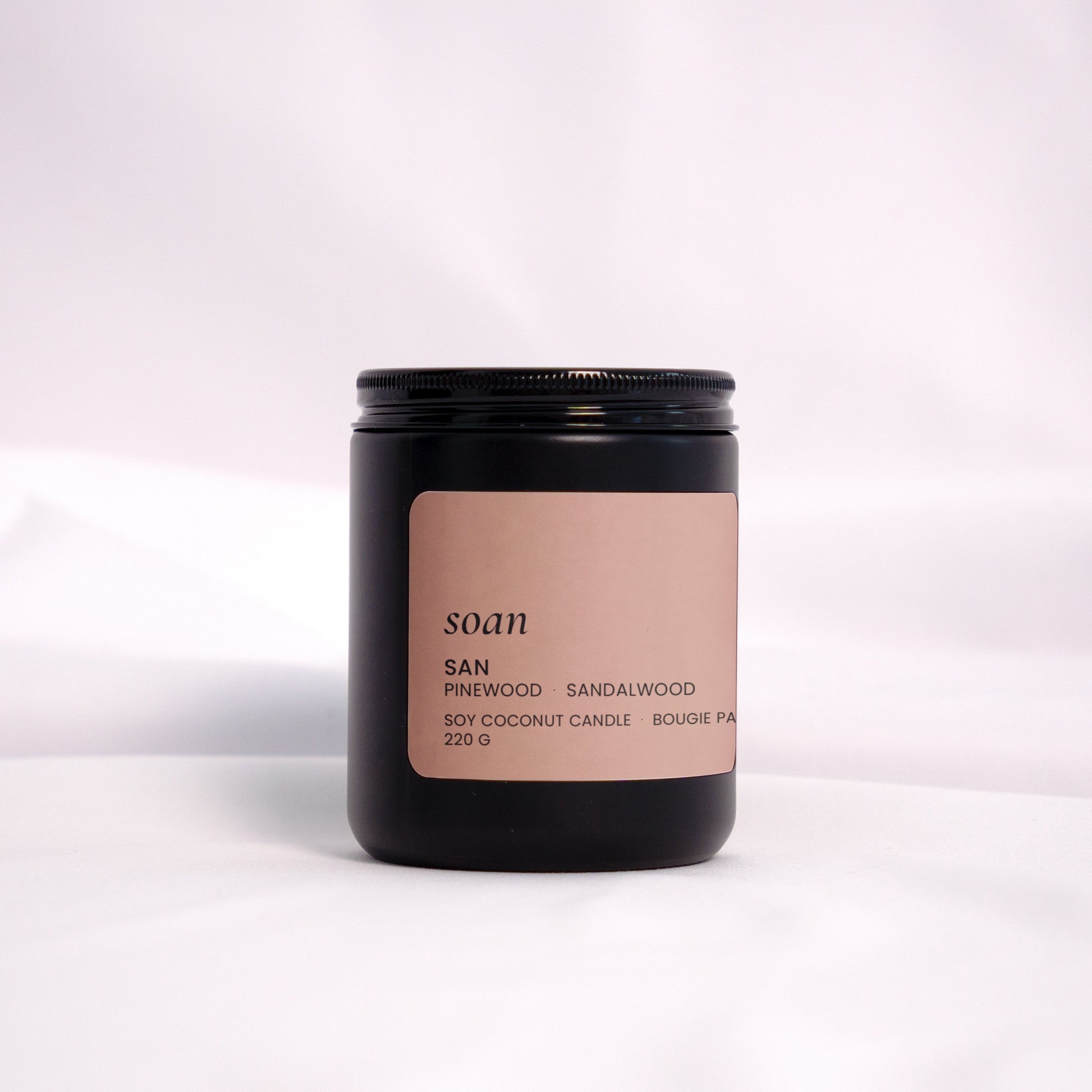 San candle styled on natural textures, evoking a serene forest atmosphere with earthy, woodsy notes