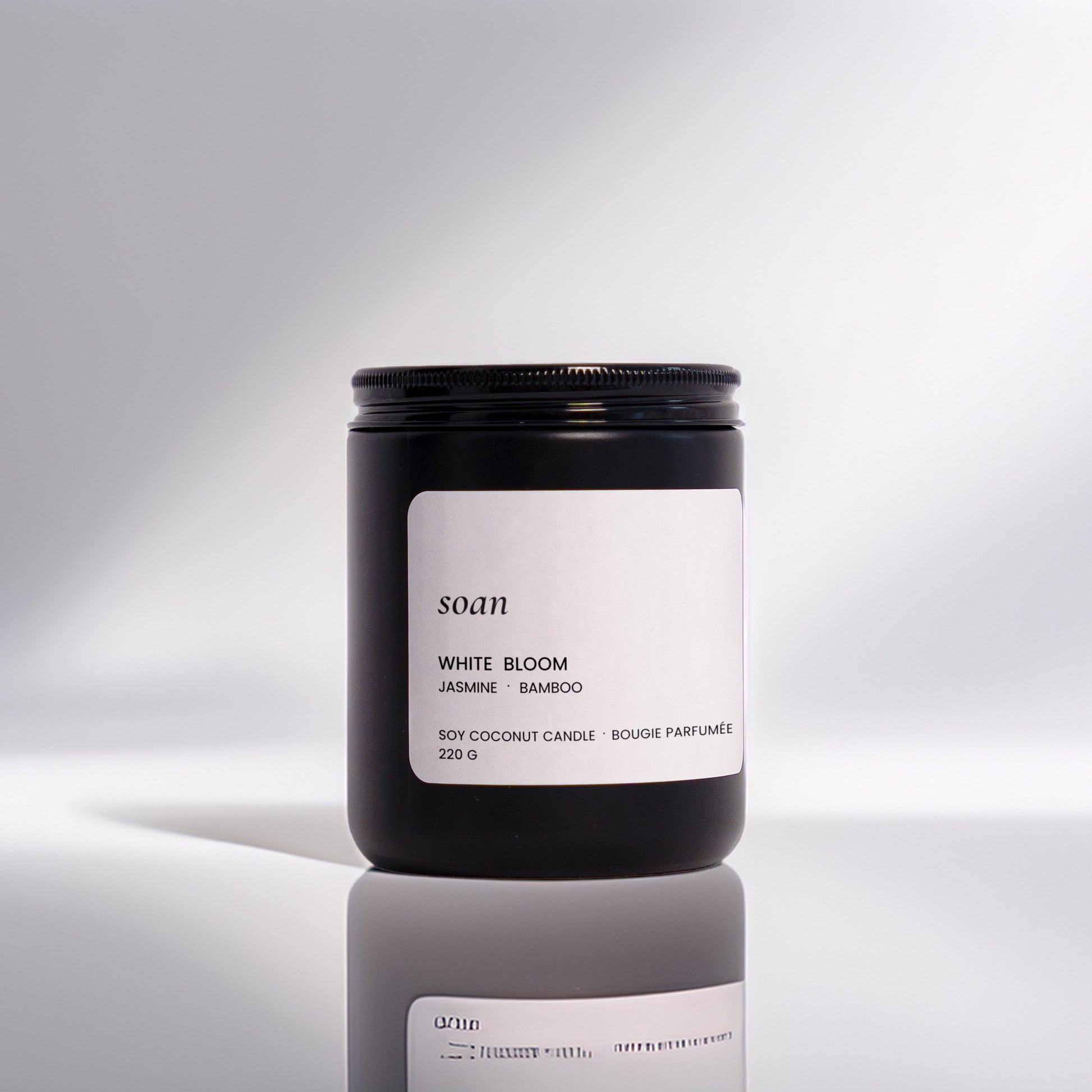 Candle jar with a label on a reflective surface