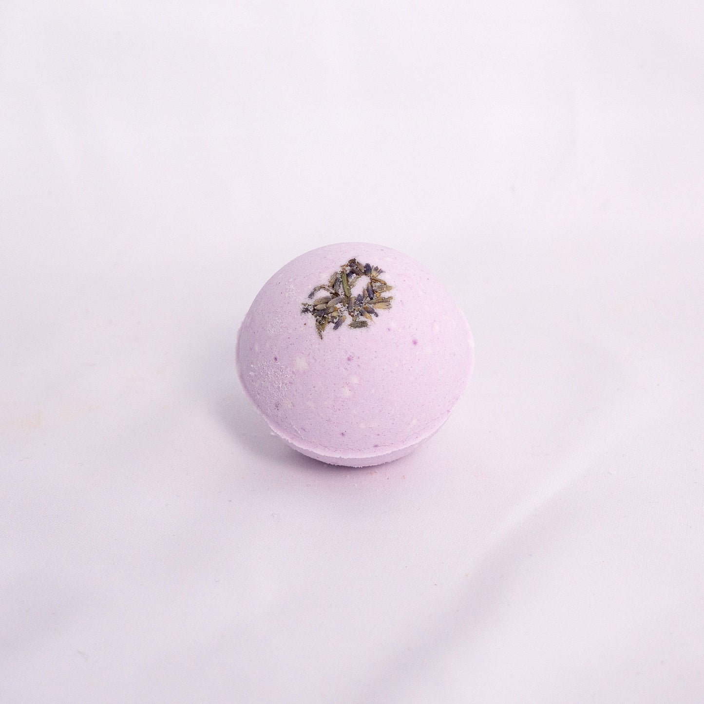 Lavender bath bomb with natural texture, hand-pressed and infused with relaxing aromatherapy bath
