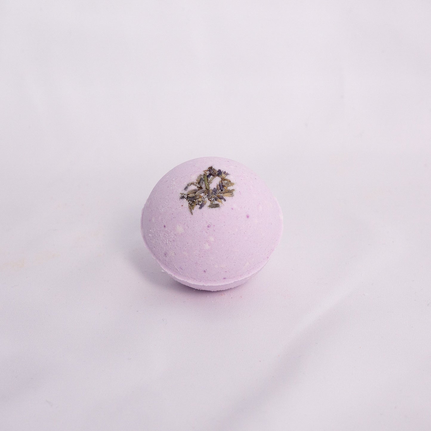 Close-up of Lavender bath bomb on a clean surface, crafted with milk powder, shea butter, and avocado oil and lavender essential oil for soft hydration and aromatherapy bath