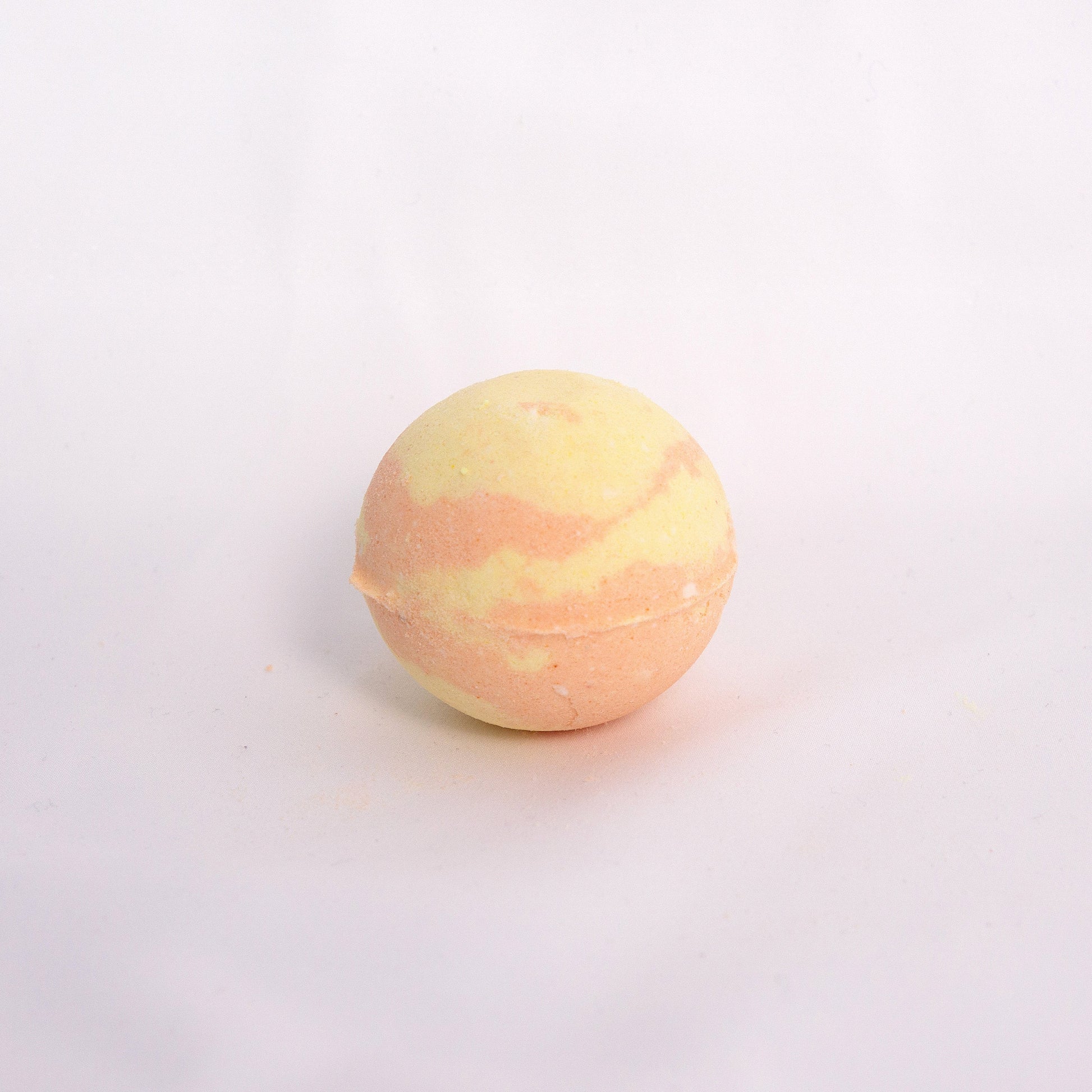 Fizzing Yuja bath bomb in water, releasing creamy bubbles and a fresh citrus yuzu aromas