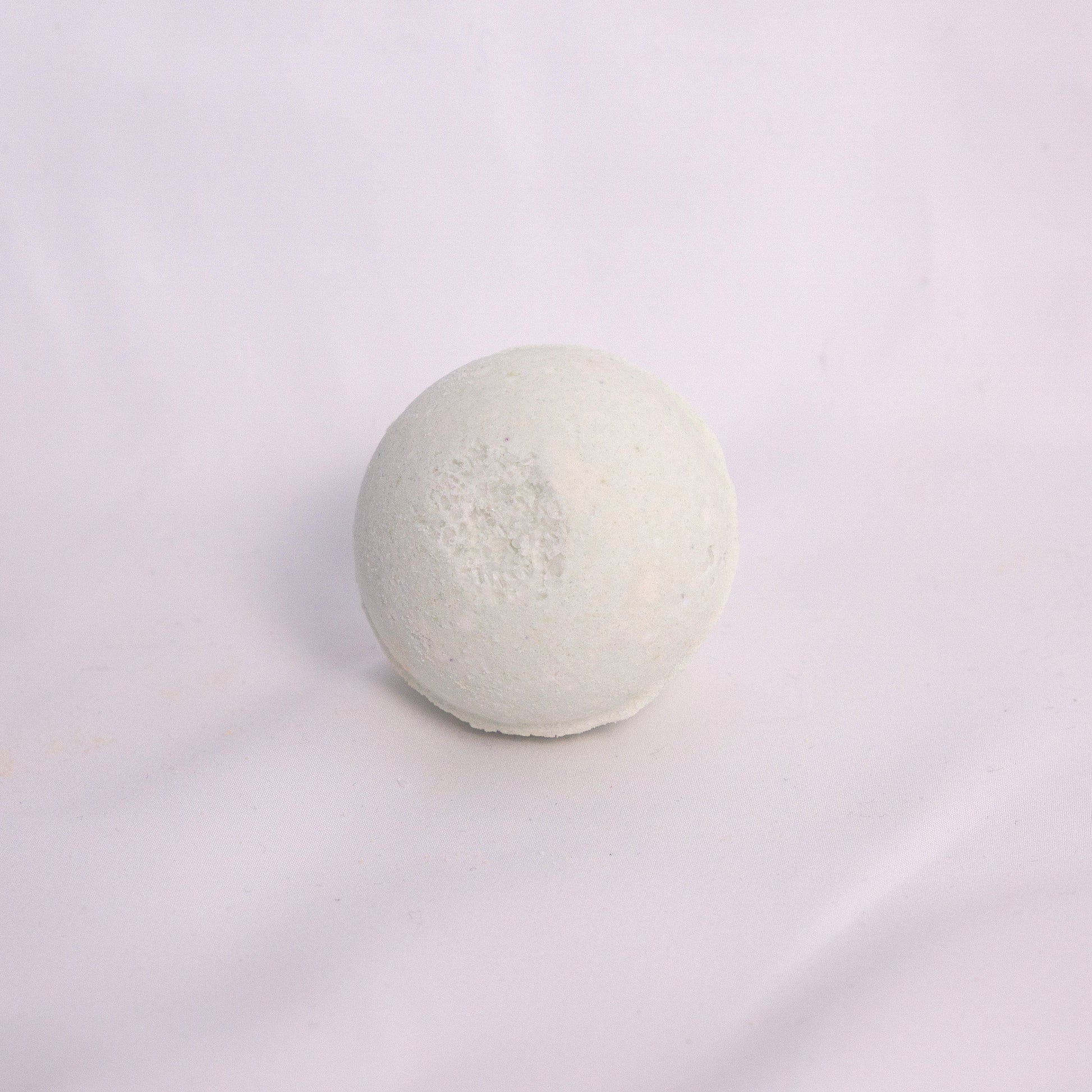 Fizzing forest bath bomb in water, releasing earthy bubbles with notes of cedar, pine, and fresh greenery