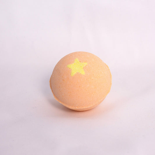 Close-up of Mango Bubble Bath Bomb on neutral surface, made with milk powder, shea butter, and avocado oil