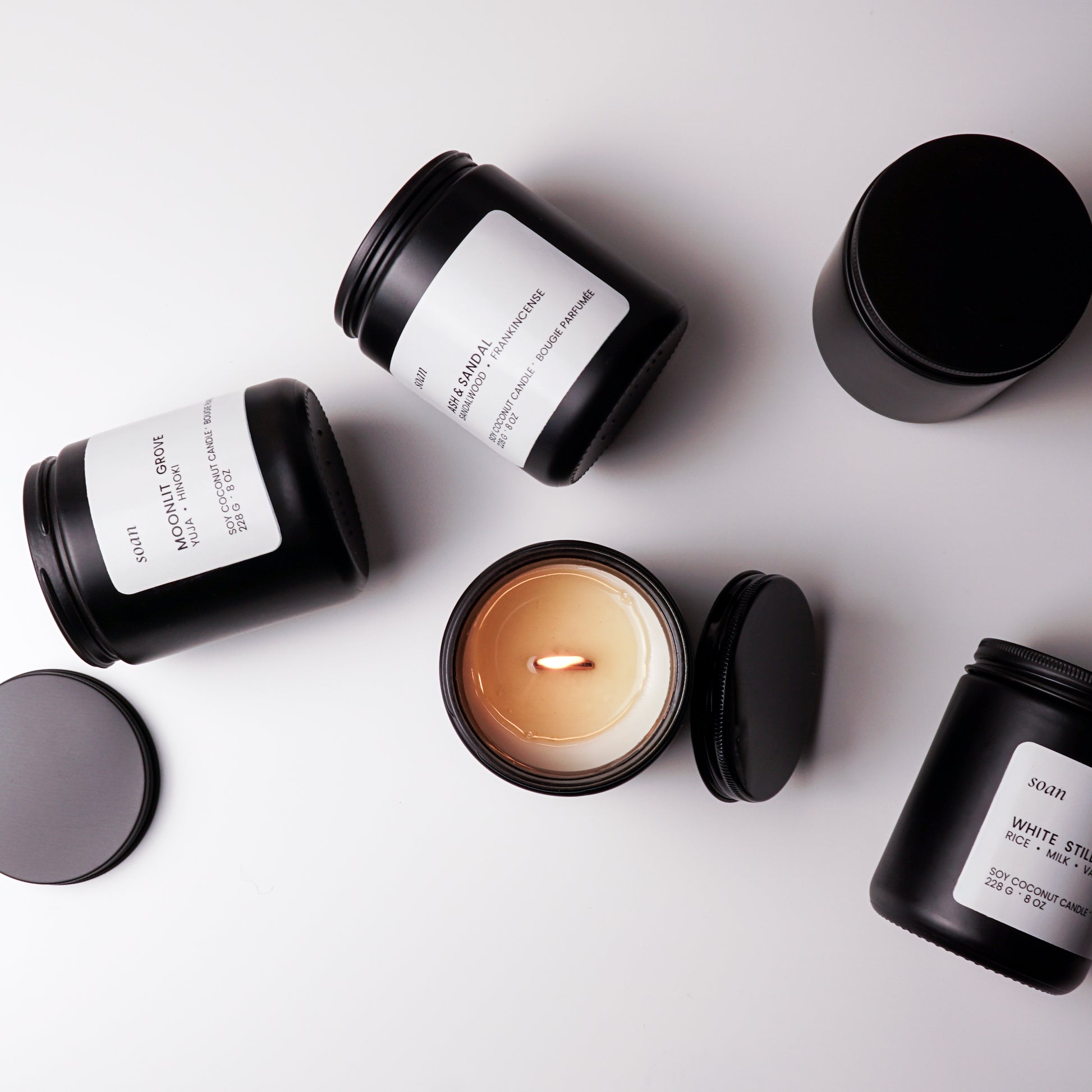 Black candles with white labels on a light gray background