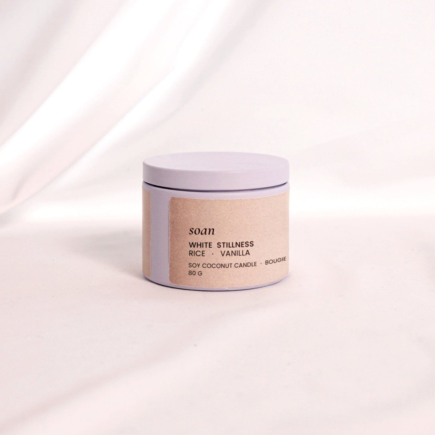 Close-up of White Stillness tin candle with smooth soy-coconut wax, evoking warmth and peaceful sweetness

