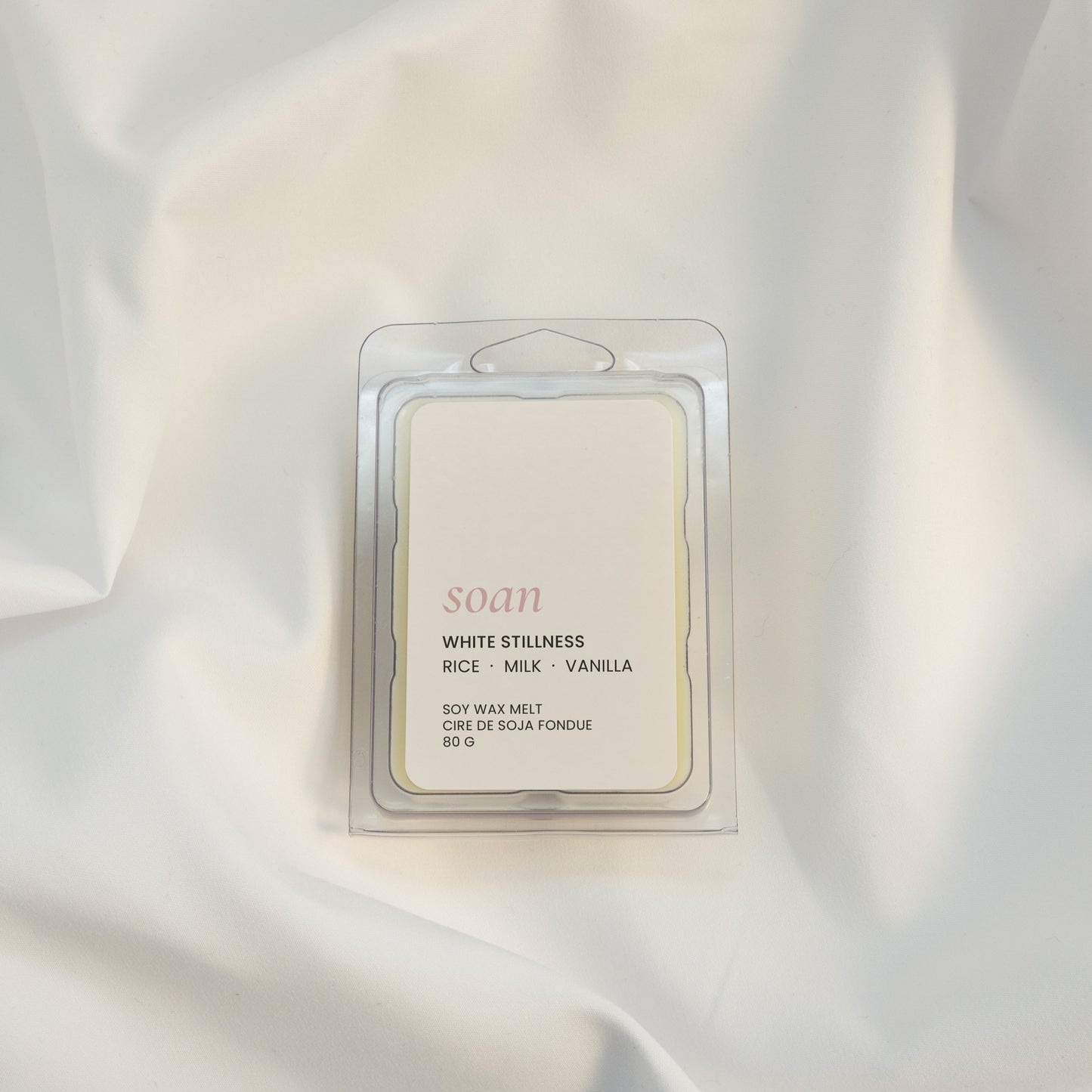 Candle packaging on a textured white fabric background
