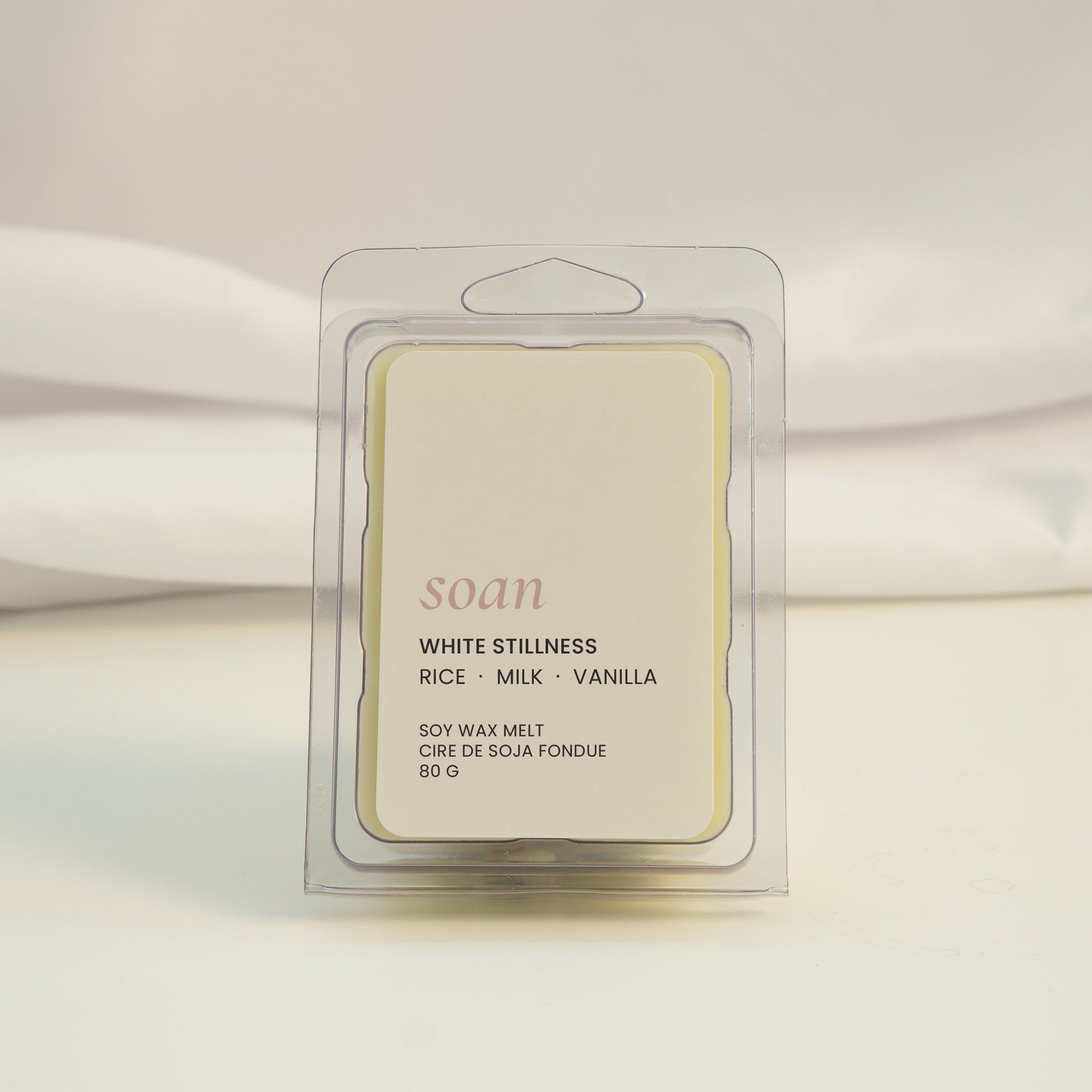 Scented wax melt packaging with 'soan' branding on a white fabric background