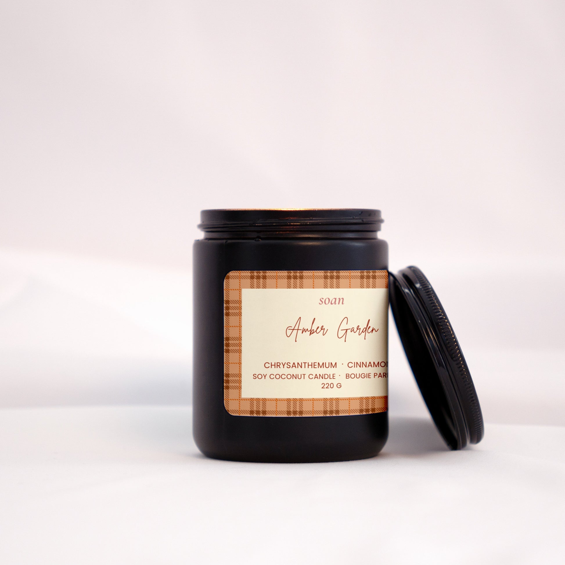 Black candle jar with a label on a white background