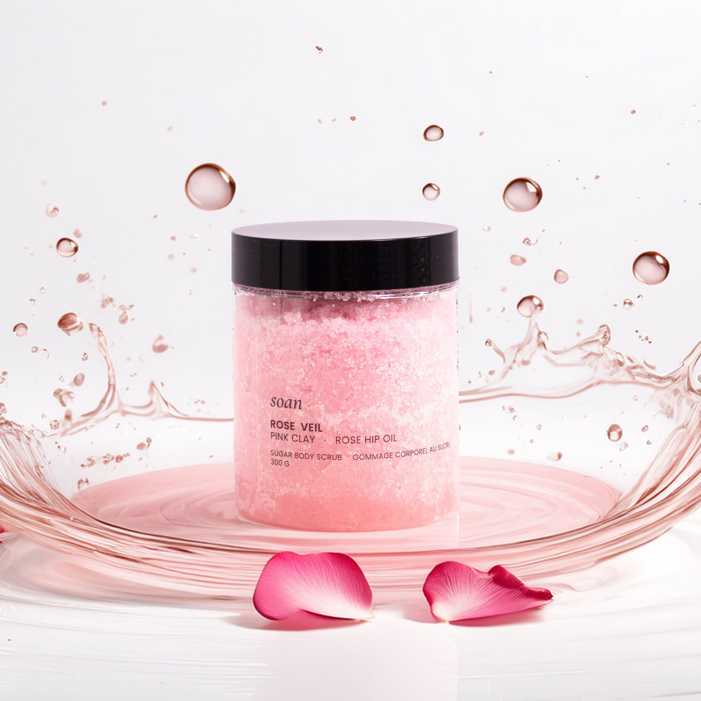 Pink skincare product Rose Sugar Scrub with water splash and rose petals on a white background