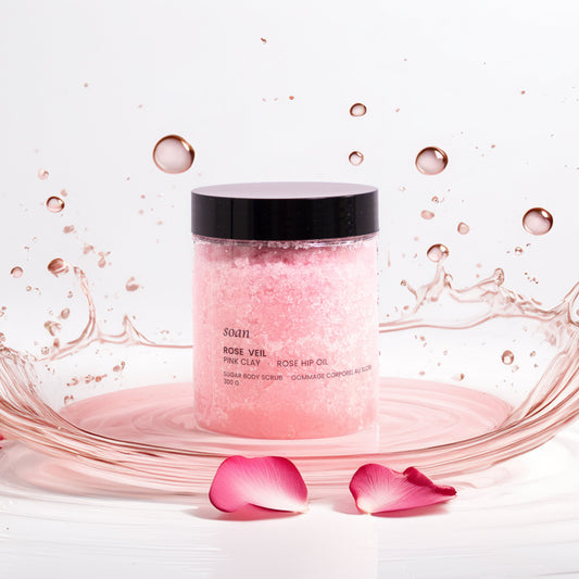 Pink skincare product Rose Sugar Scrub with water splash and rose petals on a white background