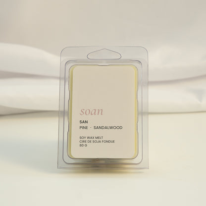 Wax melt packaging labeled 'soan' on a white fabric background