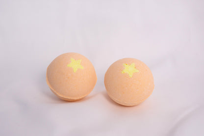 Fizzing Mango bath bomb in water, releasing soft bubbles and a vibrant, fruity aroma for a relaxing self-care ritual