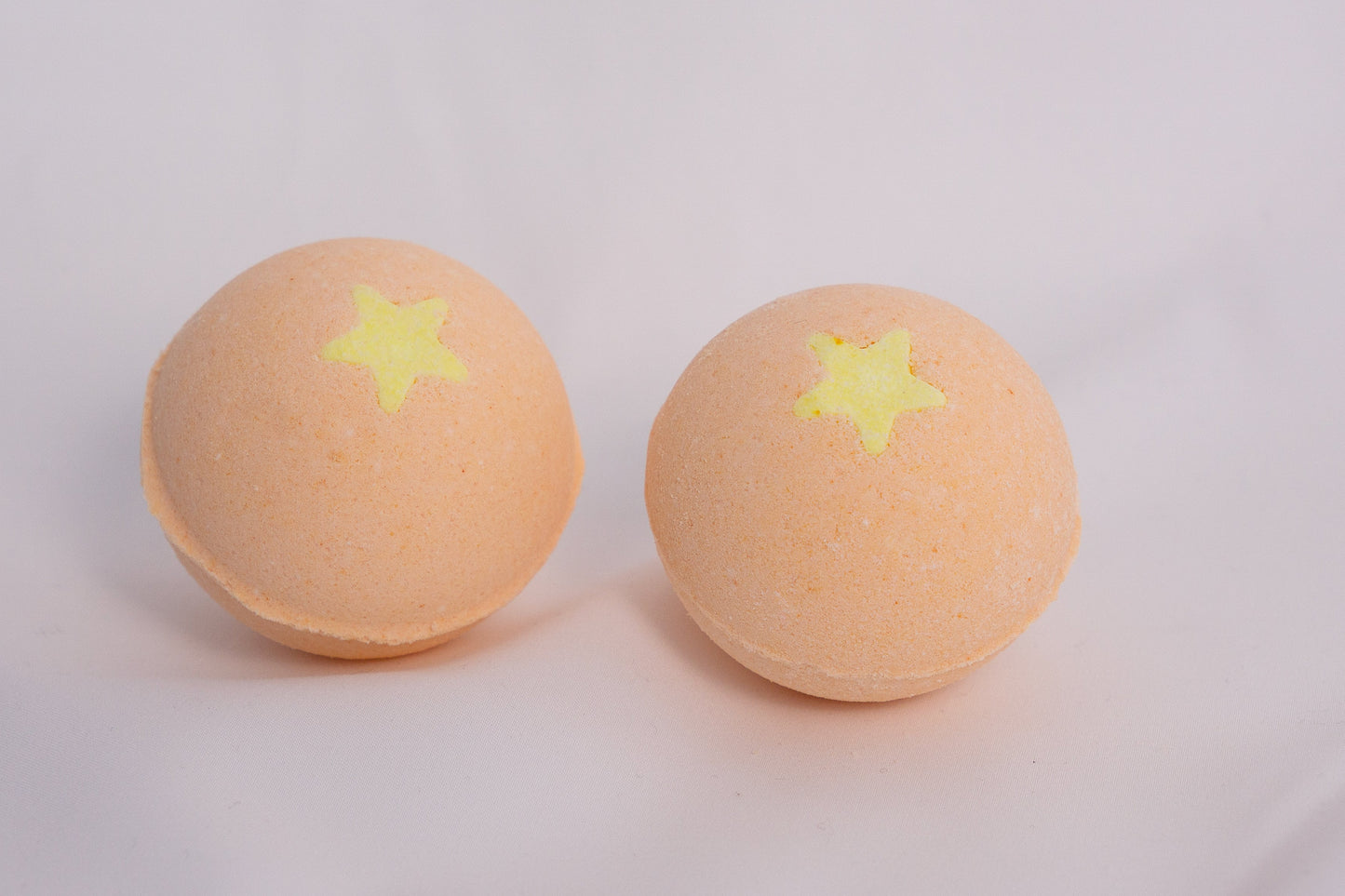 Fizzing Mango bath bomb in water, releasing soft bubbles and a vibrant, fruity aroma for a relaxing self-care ritual