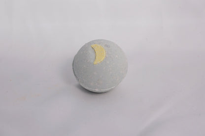 Earthy bath bomb on a neutral surface, crafted with essential oils and skin-soothing ingredients for a calming soak