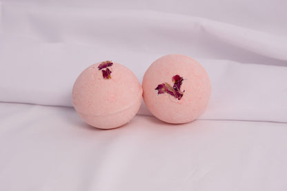 Fizzing rose bath bomb in warm water, releasing soft bubbles and a classic rose scent for a calming soak