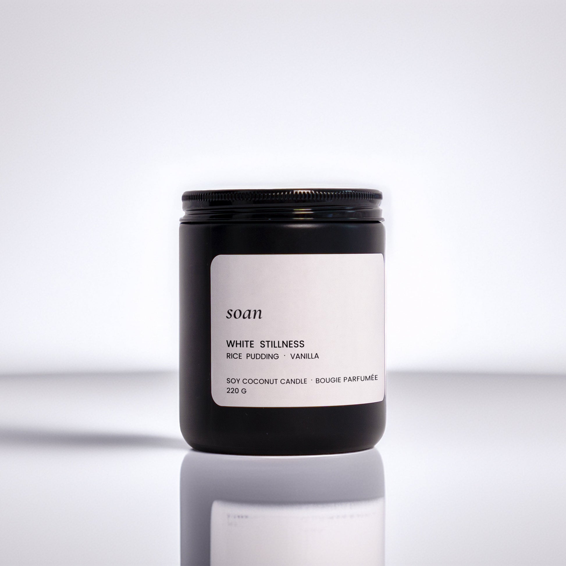 Candle jar with a label on a reflective surface