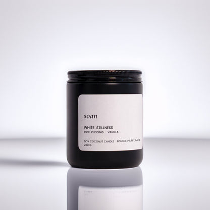 Candle jar with a label on a reflective surface