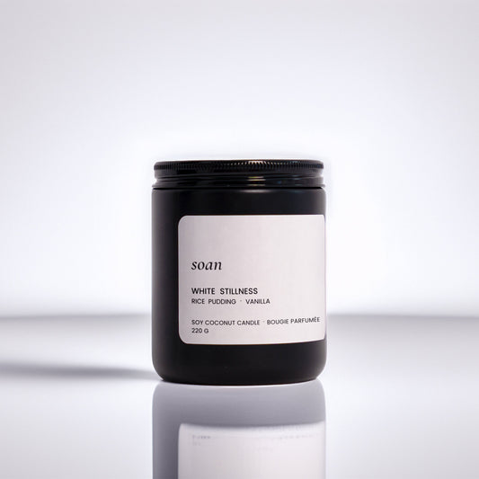 Candle jar with a label on a reflective surface