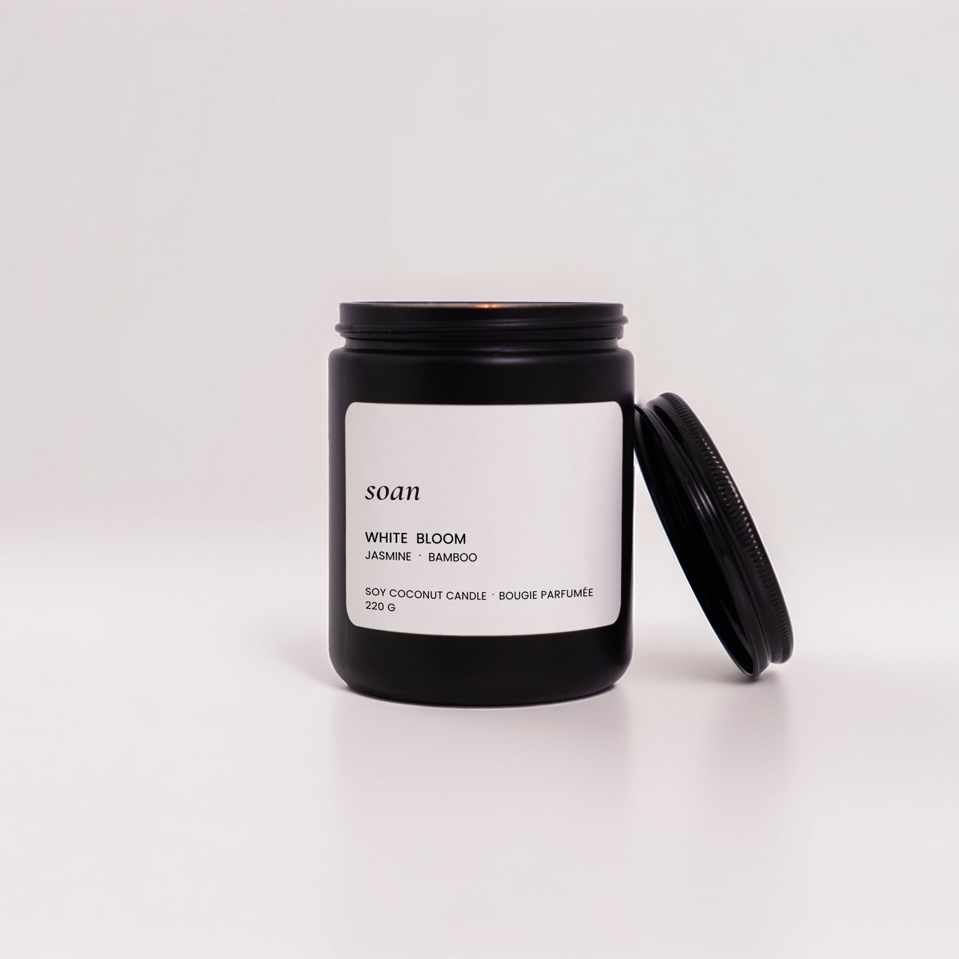 Black candle jar with white label on a white background