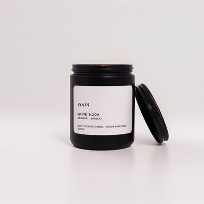 Black candle jar with white label on a white background